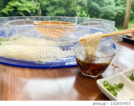 回転している流しそうめんを食べる様子。日本の夏の風物詩。 132053455