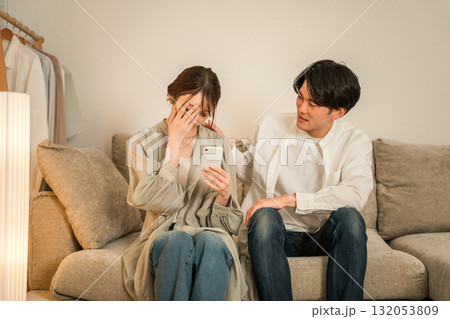 ソファーで落ち込む女性を慰める男性,夫婦,カップル（SNS,誹謗中傷） 132053809
