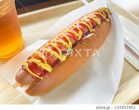トマトケチャップとマスタードソースをトッピングしたジューシーなホットドッグ。 トマトケチャップとマスタードソースをトッピングしたジューシーなホットドッグ。 132053952