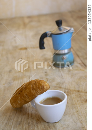 italian breakfast with espresso coffee croissant and moka pot on rustic wooden table 132054326