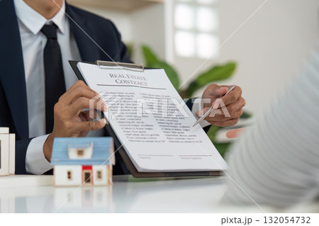 Real Estate Agent Presenting Contract to Client for Property Purchase Real Estate Agent Presenting Contract to Client for Property Purchase 132054732