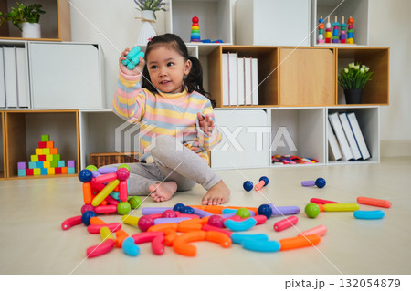 toddler girl playing colorful magnetic construction toy toddler girl playing colorful magnetic construction toy 132054879