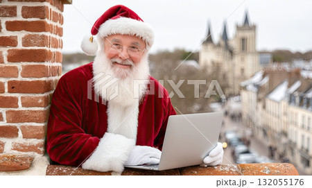 A cheerful figure in a warm red robe operates a laptop on a winter rooftop, surrounded by a snowy cityscape 132055176
