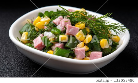 A bright salad featuring vegetables and herbs rests in a bowl, set against a backdrop of sparkling lights and a holiday tree 132055480