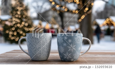 Two cups sit on a wooden table, surrounded by festive decorations and people enjoying a lively outdoor market on a rainy day 132055610