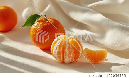 Fresh Orange With Peel Segments On Soft White Fabric For Bright, Healthy Food Photography Fresh Orange With Peel Segments On Soft White Fabric For Bright, Healthy Food Photography 132056526
