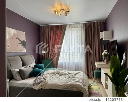 a modern bedroom in a stylish interior of a new apartment with designer renovation 132057384