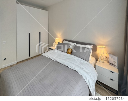 a modern bedroom in a stylish interior of a new apartment with designer renovation 132057984