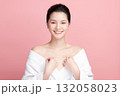 A beautiful young Asian woman with clean, fresh skin against a pink background. Skincare, facial treatment, cosmetology, beauty, and spa. An elegant portrait of an Asian woman. 132058023