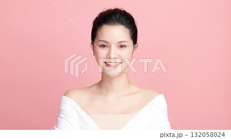 A beautiful young Asian woman with clean, fresh skin against a pink background. Skincare, facial treatment, cosmetology, beauty, and spa. An elegant portrait of an Asian woman. 132058024