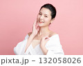 A beautiful young Asian woman with clean, fresh skin against a pink background. Skincare, facial treatment, cosmetology, beauty, and spa. An elegant portrait of an Asian woman. 132058026