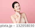 A beautiful young Asian woman with clean, fresh skin against a pink background. Skincare, facial treatment, cosmetology, beauty, and spa. An elegant portrait of an Asian woman. 132058030