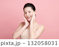 A beautiful young Asian woman with clean, fresh skin against a pink background. Skincare, facial treatment, cosmetology, beauty, and spa. An elegant portrait of an Asian woman. 132058031