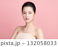 A beautiful young Asian woman with clean, fresh skin against a pink background. Skincare, facial treatment, cosmetology, beauty, and spa. An elegant portrait of an Asian woman. 132058033