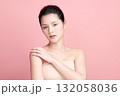 A beautiful young Asian woman with clean, fresh skin against a pink background. Skincare, facial treatment, cosmetology, beauty, and spa. An elegant portrait of an Asian woman. 132058036