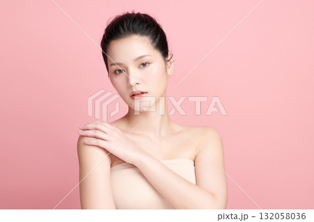 A beautiful young Asian woman with clean, fresh skin against a pink background. Skincare, facial treatment, cosmetology, beauty, and spa. An elegant portrait of an Asian woman. 132058036
