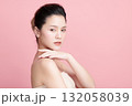 A beautiful young Asian woman with clean, fresh skin against a pink background. Skincare, facial treatment, cosmetology, beauty, and spa. An elegant portrait of an Asian woman. 132058039