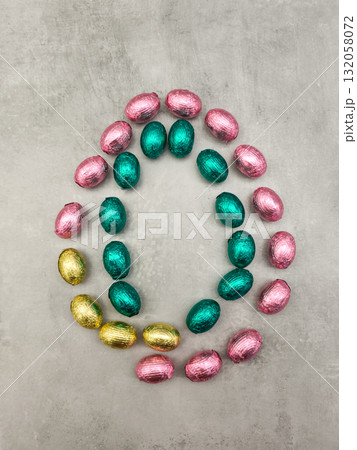 Colorful chocolate eggs forming an oval shape for easter celebration copy space 132058072