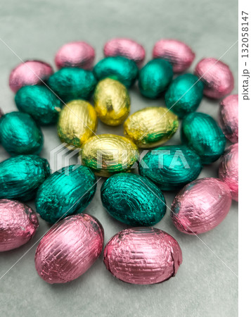 Chocolate easter eggs forming colorful spiral on grey background Chocolate easter eggs forming colorful spiral on grey background 132058147