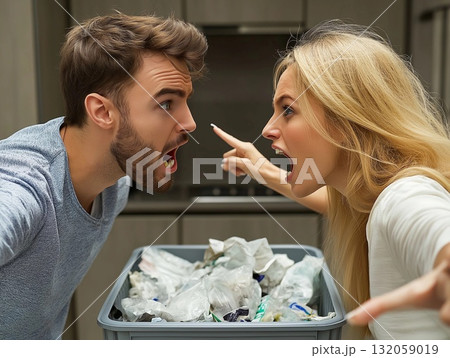 Angry couple debating over waste management in a messy kitchen during a heated argument 132059019