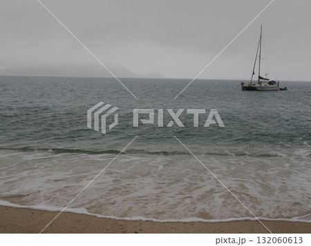 フィッツロイ島–曇天の海に浮かぶヨットと遠景の島影 フィッツロイ島–曇天の海に浮かぶヨットと遠景の島影 132060613