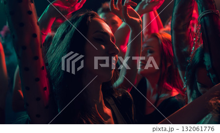 Close up of woman enjoying music at colorful New Year dance floor Close up of woman enjoying music at colorful New Year dance floor 132061776