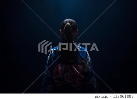 暗い空間で背中を向けている晴れ着の若い女性 暗い空間で背中を向けている晴れ着の若い女性 132061895