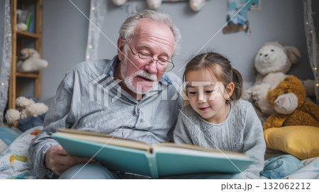 Grandpa reading bedtime stories to granddaughter in cozy bedroom, surrounded by stuffed animals, highlighting multigenerational family connection and love Grandpa reading bedtime stories to granddaughter in cozy bedroom, surrounded by stuffed animals, highlighting multigenerational family connection and love 132062212