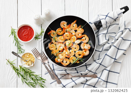 rosemary and garlic seared shrimps in a skillet 132062425