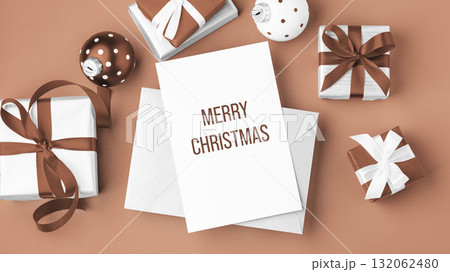 Merry christmas background, paper holiday greeting card with gift boxes and xmas ball on mocha mousse color background 132062480