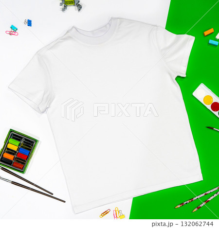 Trendy fashion T-shirt white styled basic clothes and accessories collection on white and green background. Flat lay, top view. Chess, book, pensils. Trendy fashion T-shirt white styled basic clothes and accessories collection on white and green background. Flat lay, top view. Chess, book, pensils. 132062744