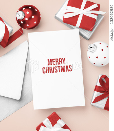 Christmas holiday greeting card with envelope and gift box and xmas ball decoration on light beige background 132062980
