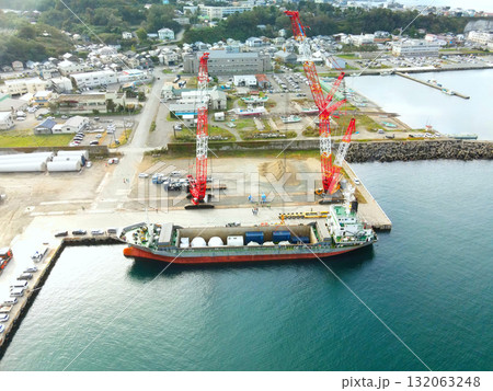 秋の北海道江差町で風力発電風車搬出基地の風景を空撮 132063248