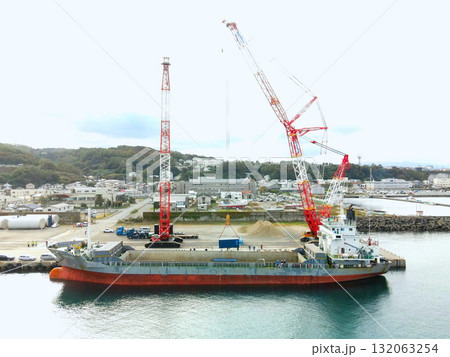 秋の北海道江差町で風力発電風車搬出基地の風景を空撮 132063254