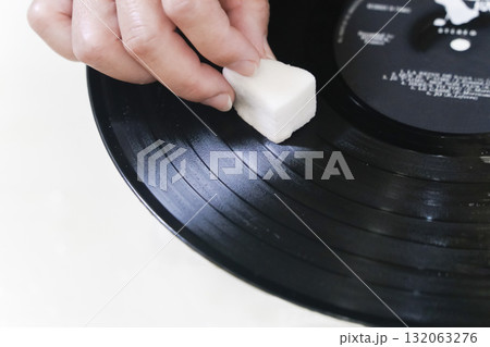 汚れた古いレコード盤をスポンジで拭く 132063276