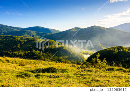 countryside mountain landscape in autumn. rural field on green hill. beautiful scenery with grassy meadow and forested slope in highland of ukraine under blue sky. scenic carpathian view in afternoon countryside mountain landscape in autumn. rural field on green hill. beautiful scenery with grassy meadow and forested slope in highland of ukraine under blue sky. scenic carpathian view in afternoon 132063615