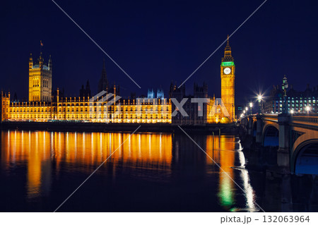 Illuminated Palace of Westminster and Elizabeth Tower reflecting in River Thames at night in London 132063964