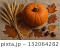 Autumn still life with pumpkin, dry leaves, wheat, and acorns on beige fabric background. Seasonal harvest decoration. 132064282
