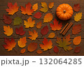 Autumn leaves, pumpkin, and cinnamon sticks on wooden background, seasonal decoration for fall. 132064285