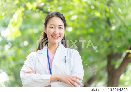 白衣の女性　屋外　新緑　腕組み 132064893