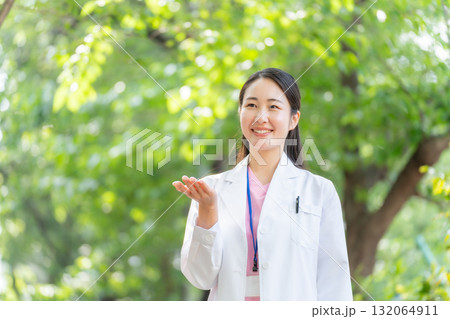 白衣の女性 屋外 新緑 手かざし 白衣の女性 屋外 新緑 手かざし 132064911