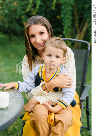 Loving Mother Holding Child In Garden Chair Loving Mother Holding Child In Garden Chair 132065417