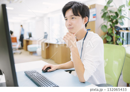 デスクトップパソコンで作業をする若いビジネスマン 132065433