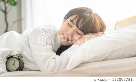 20代〜30代の日本人女性が布団で眠る朝の様子 テキストスペース 素材 16:9サイズ AI生成素材 132065781