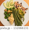 Vegetable platter with Brussels sprouts, fried mushrooms, fried leeks, steamed beans, celery puree and avocado slices 132066131