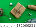 New Year holiday background. Gift, twine and paper, Christmas balls and tinsel on a green background. 132066231
