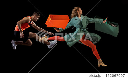 Surreal composition. Athlete and woman jumping together with colorful shopping bags on dark background Surreal composition. Athlete and woman jumping together with colorful shopping bags on dark background 132067007