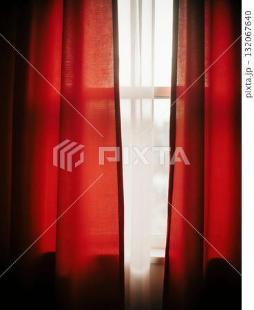 Sunlight streams through translucent red curtains, creating a warm and welcoming ambiance in a room. The soft fabric adds color and charm, illuminating the space softly Generative AI 132067640