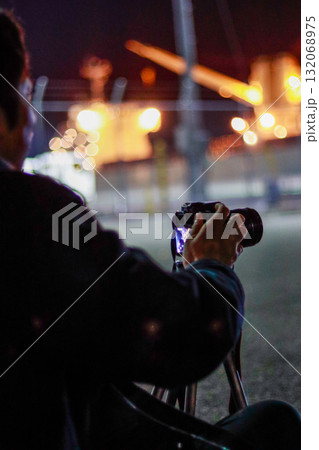 ライトアップされたカメラを構える男性 132068975