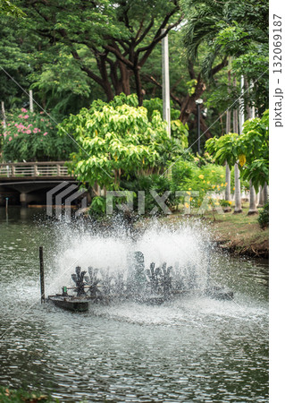 rotating water oxygen generator in park creating droplets, eco-friendly aeration device in pond producing dynamic water splashes, Lumpini park, Bangkok 132069187